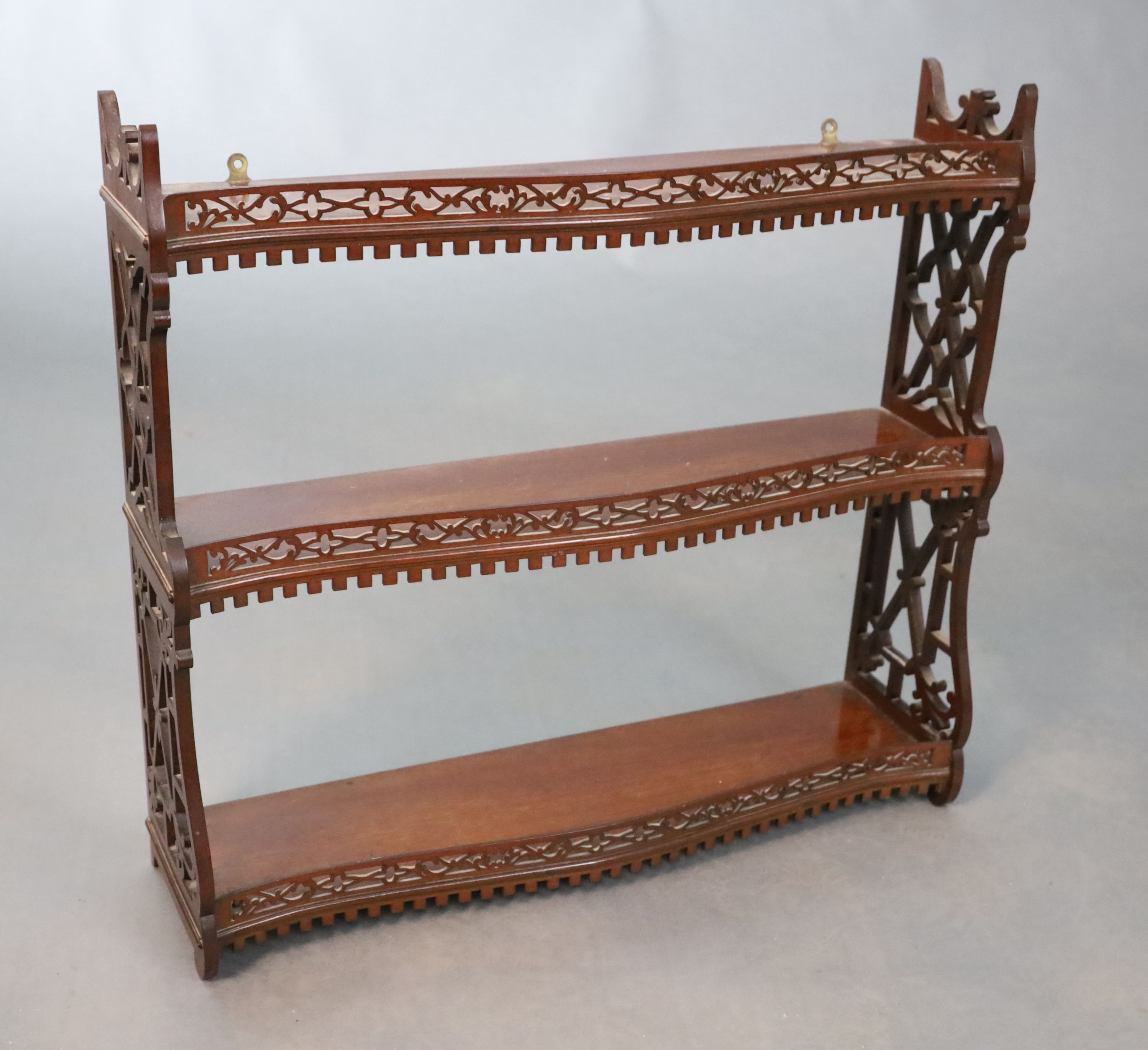 A George II style mahogany three tier wall shelf, W.66cm H.60.5cm